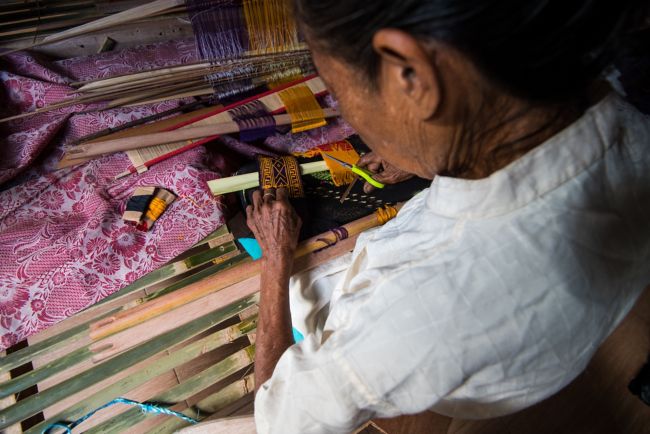 an old lady weaving Ikat