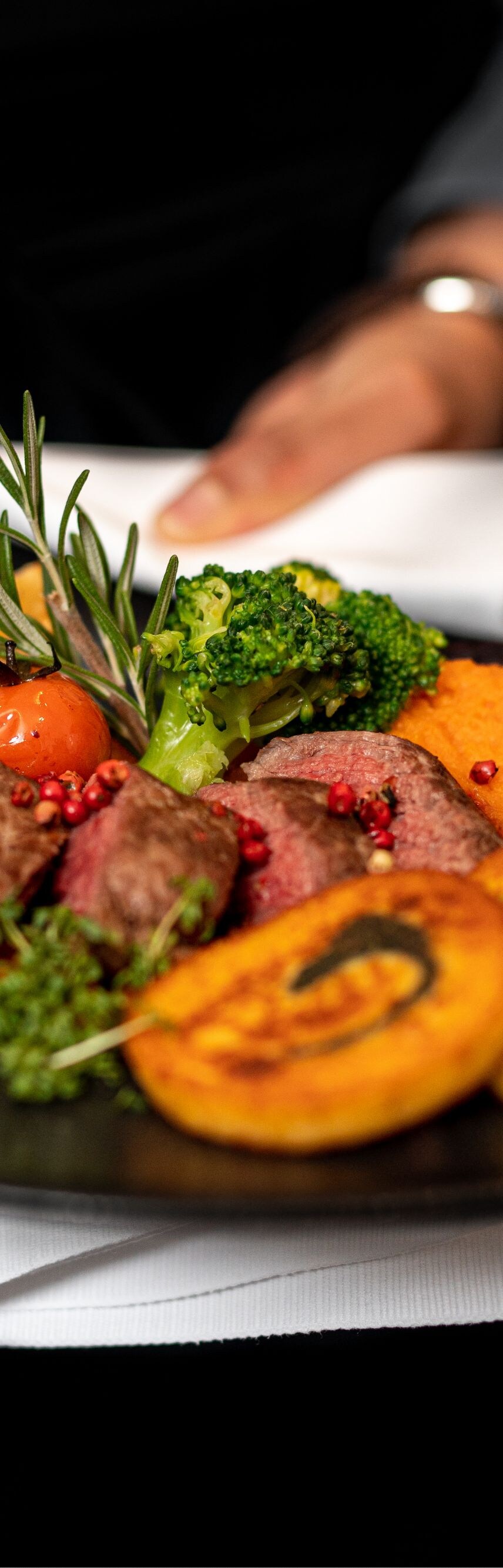 Main course with steak and sides being served