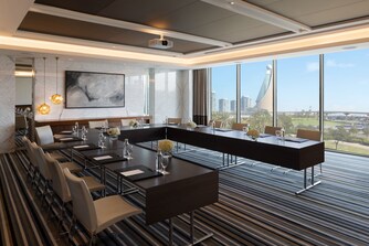 قاعة اجتماعات دبي نكزيس 5 مع طاولات على شكل حرف U.