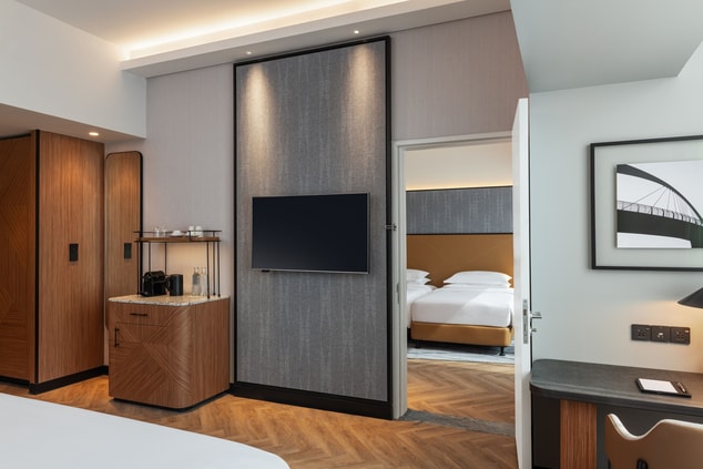 guest rooms separated by a TV-mounted wall  