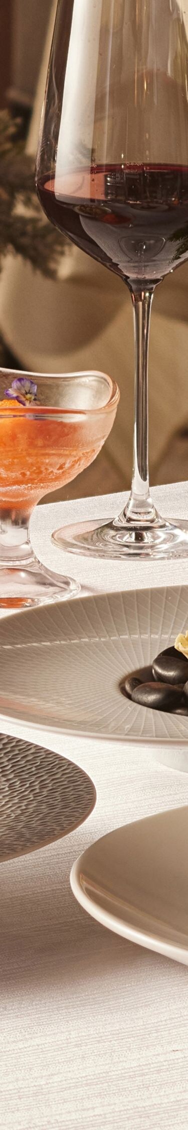 Fine dining dishes on table with Christmas decor.