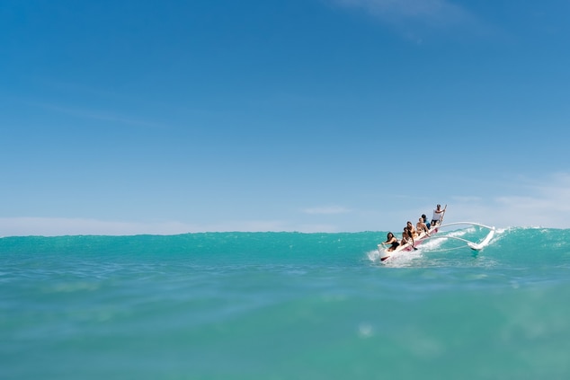 Catching waves while outrigger canoe surfing