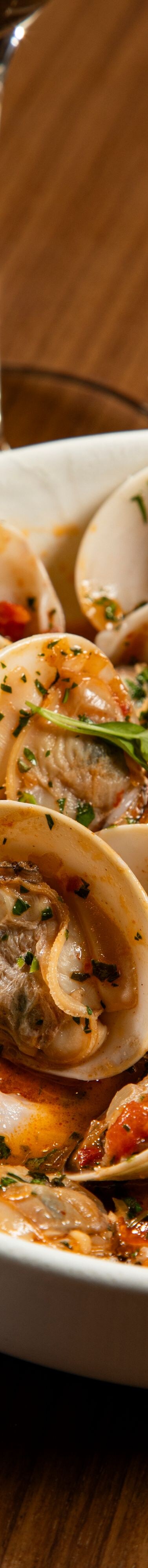 Eine Schüssel voll Muscheln in Tomatenbrühe mit geröstetem Brot