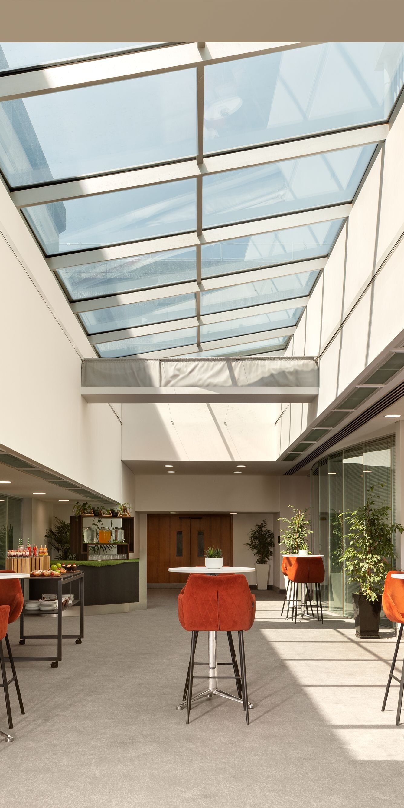Konferenzfoyer mit Glasdecke und Sitzbereichen