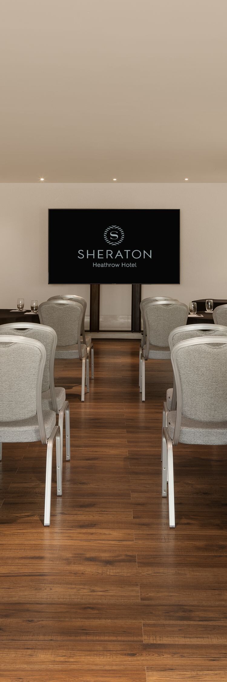 Meeting room set with round tables and a presentation screen
