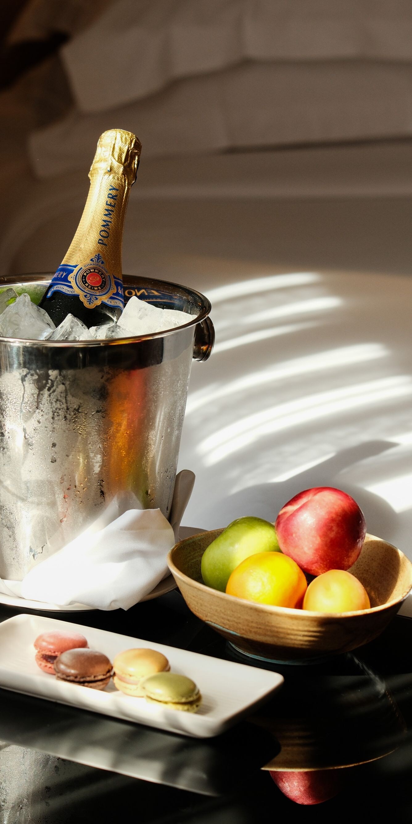 Macaron and champagne on table beside bed