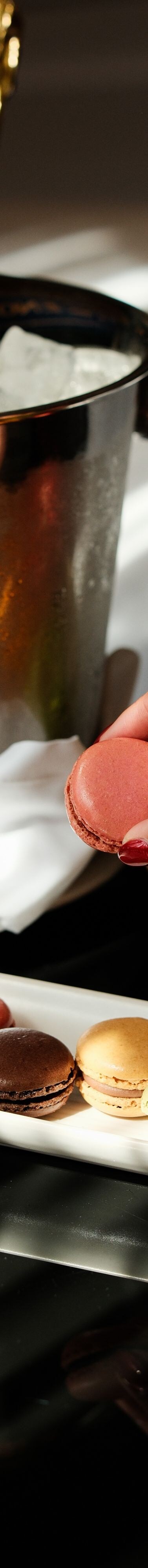 Hand picking up macaron in room