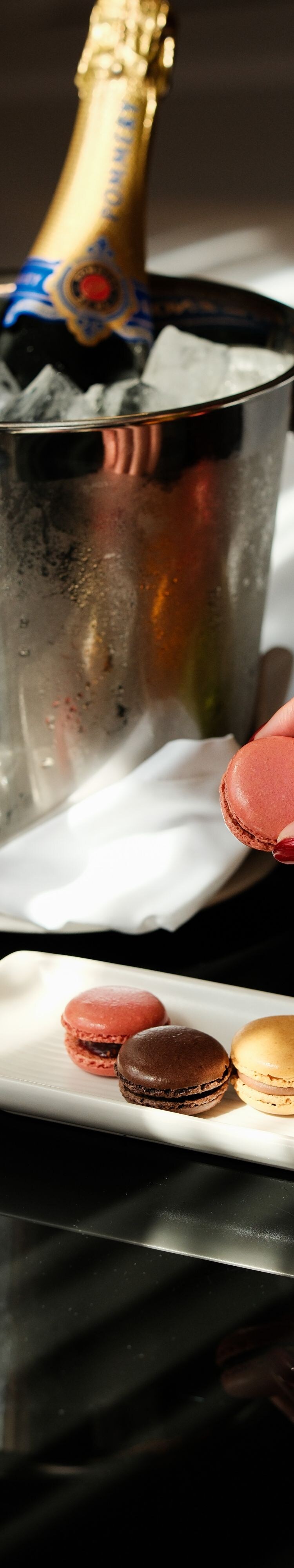Hand picking up macaron in room