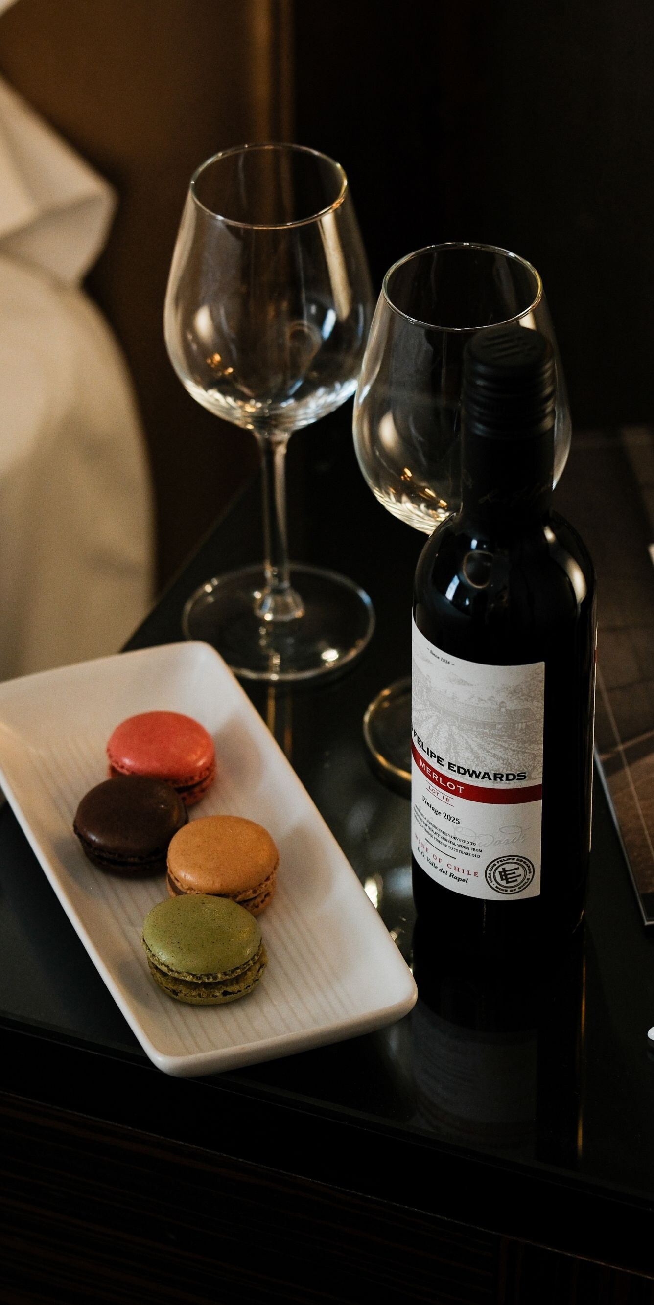 Wine and macaron on bedside table