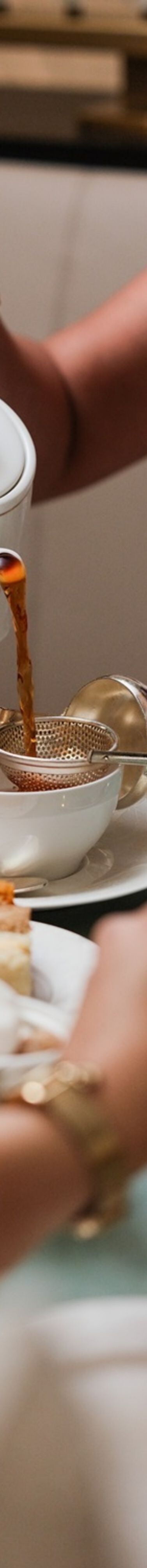 Tea poured into cup beside afternoon tea stand