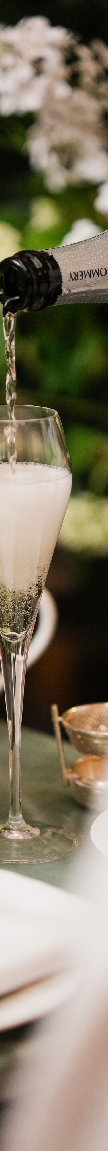 Champagne poured into flute beside tea stand
