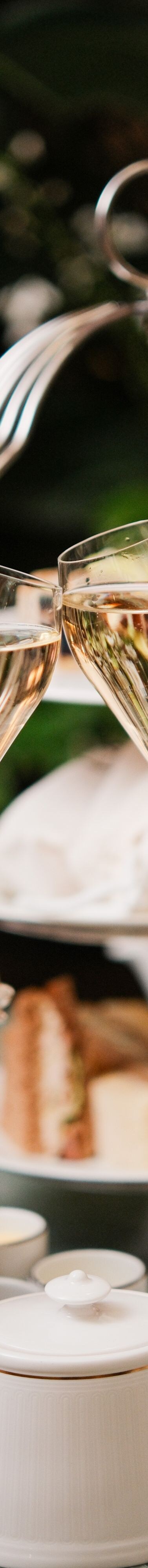 Two champagne flutes above afternoon tea table