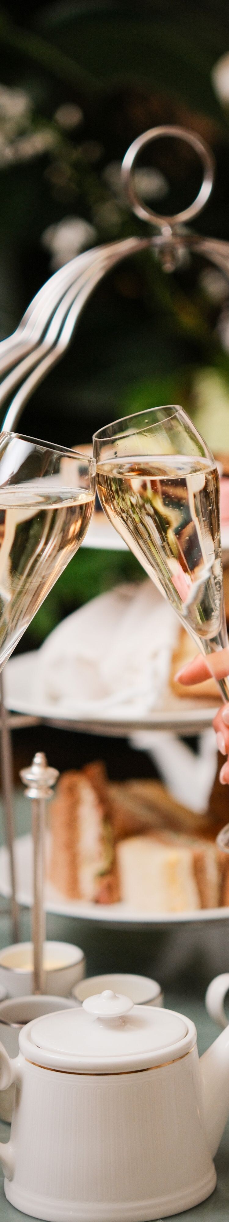 Two champagne flutes above afternoon tea table
