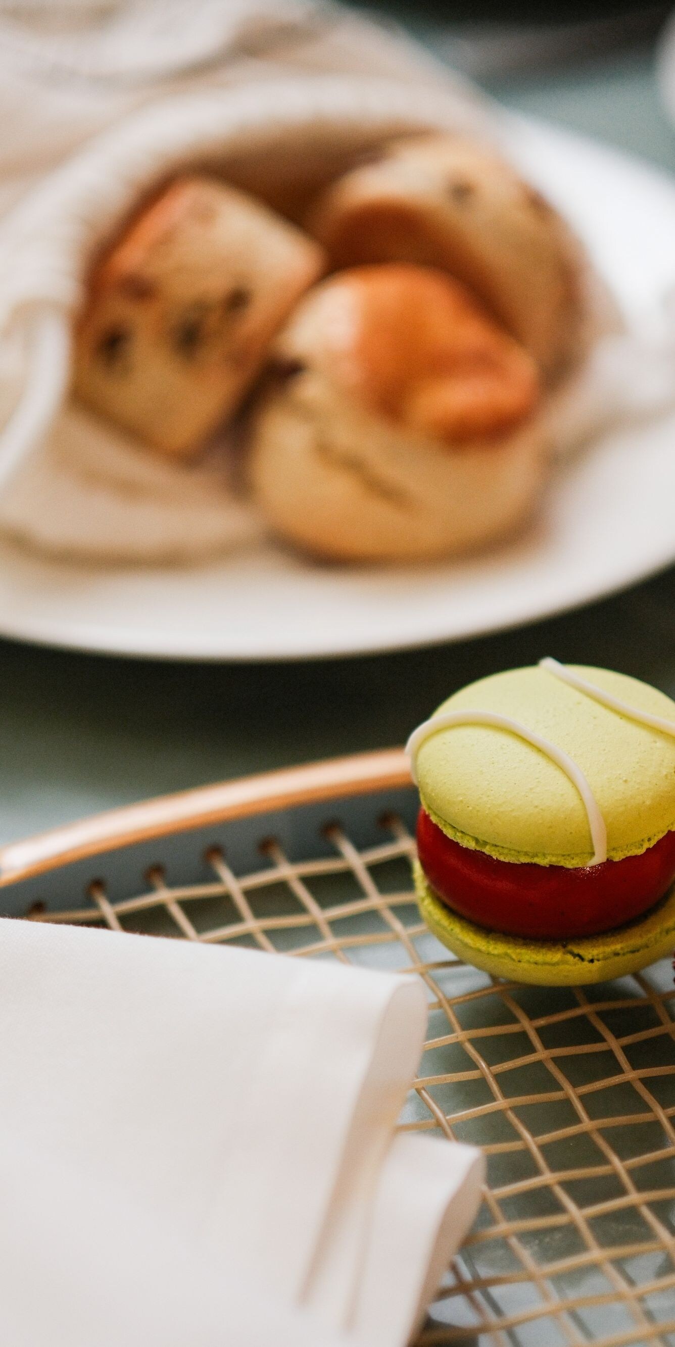Scone and cake on plate beside tea cup