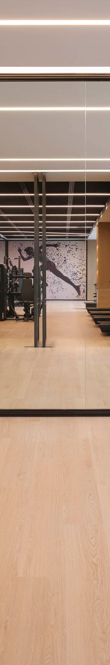 Fitness studio with weights, mirrors, and windows