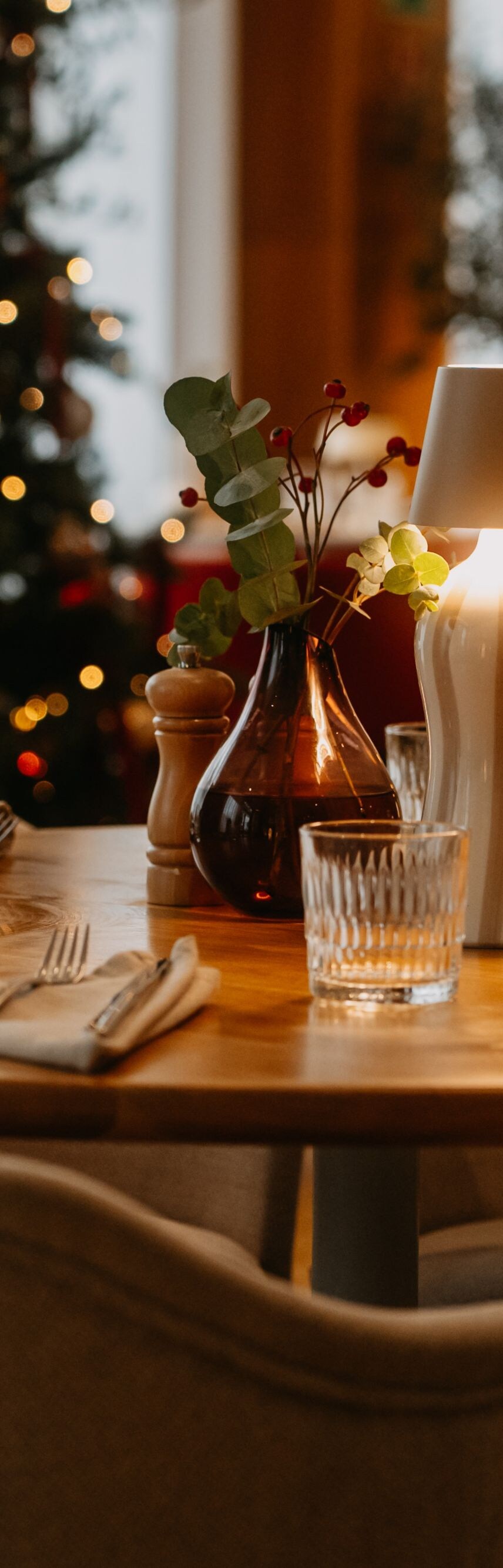 Festive restaurant table near Christmas tree