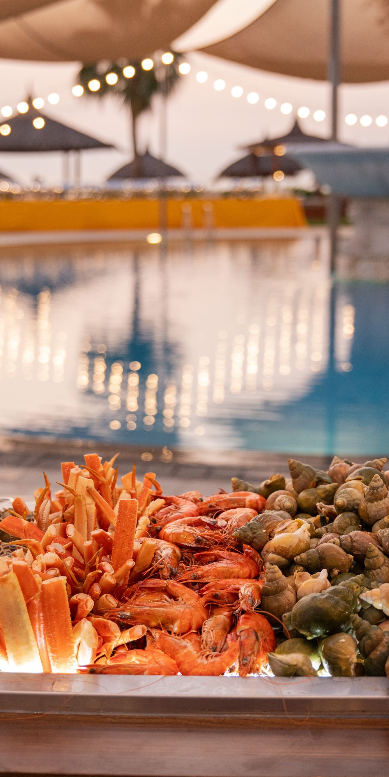 Seafood buffet with pool and string lights