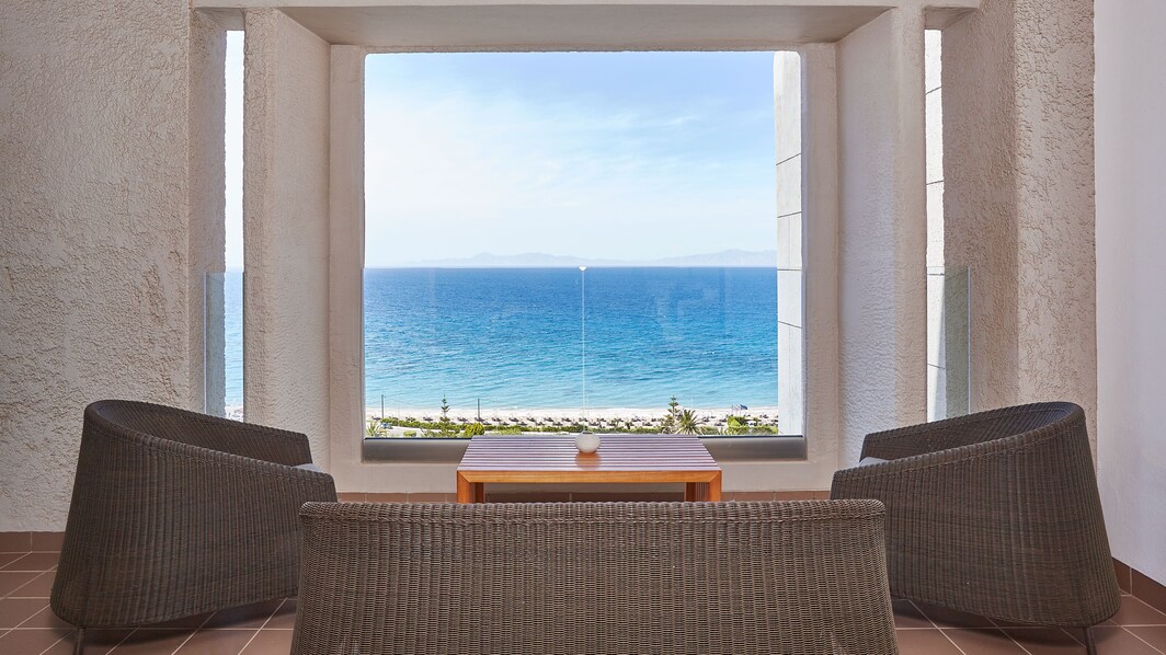 Imagen con vista al mar desde el balcón de una suite Aelia con sala de estar