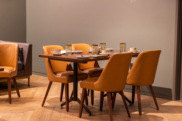 4 yellow chairs around a wood dining table