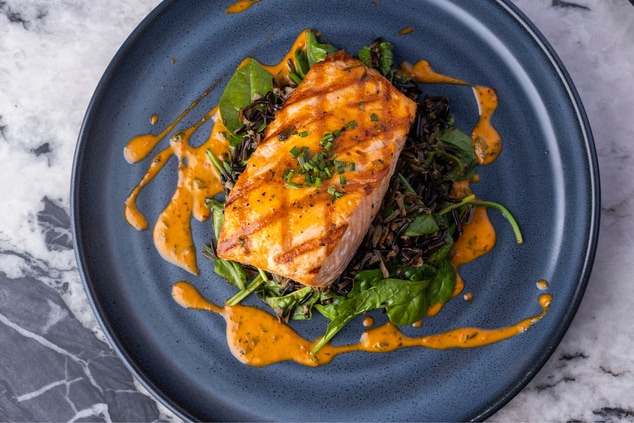 Salmon cooked to perfection on a bed of greens