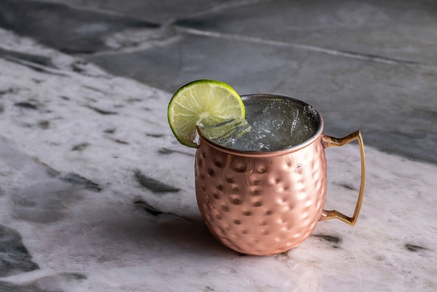 A moscow mule in a brass cup with lime