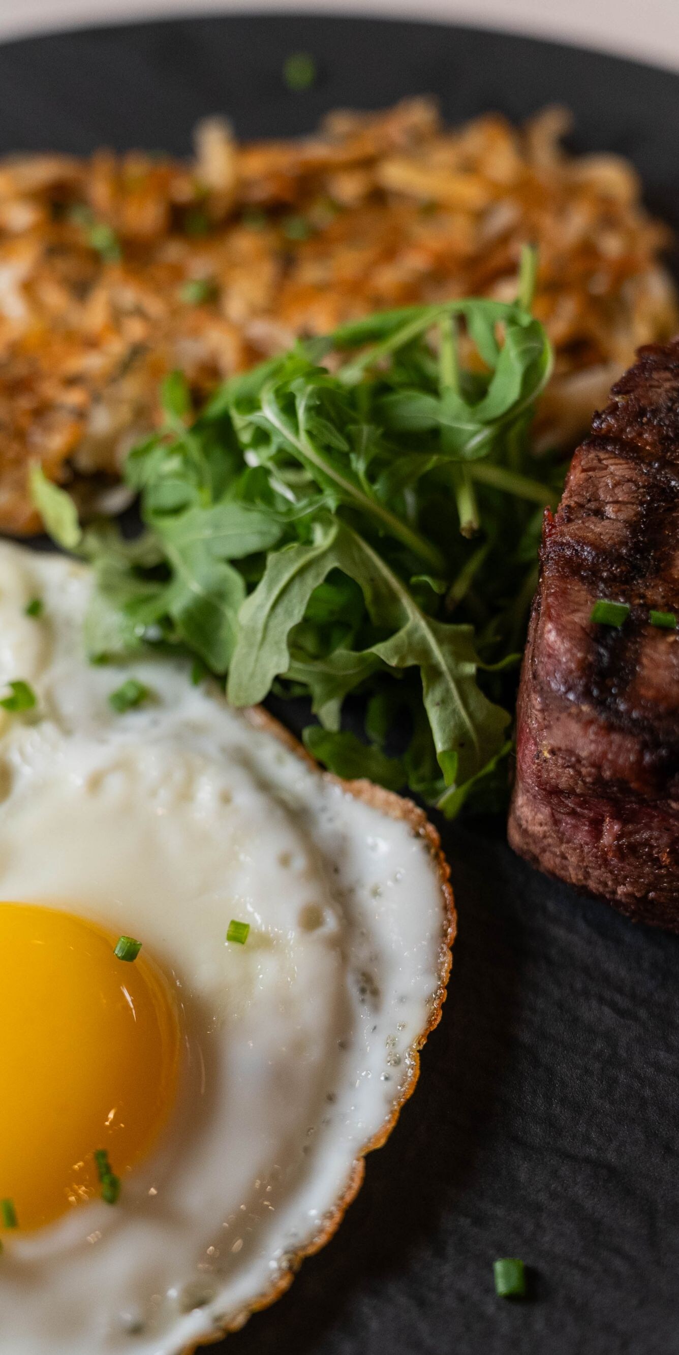 Grilled steak with sunny-side eggs and hash