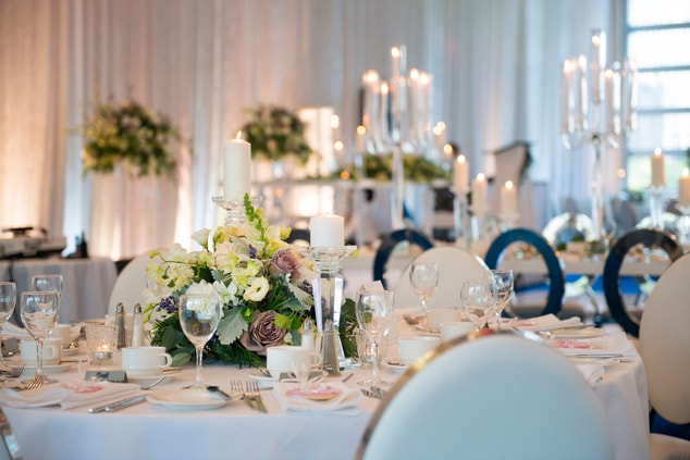 Table topped with flowers, candles, and serveware.