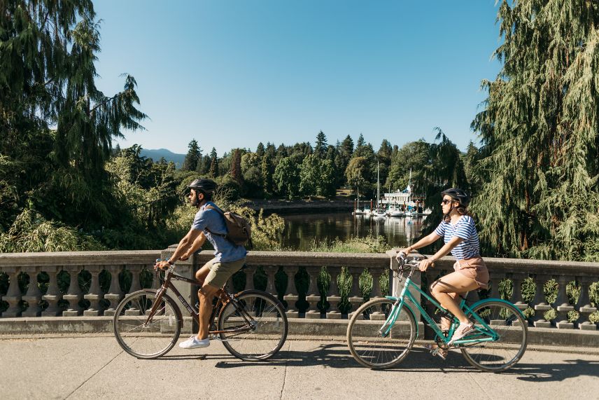 Couple cycling across a bridge in Stanley Park.