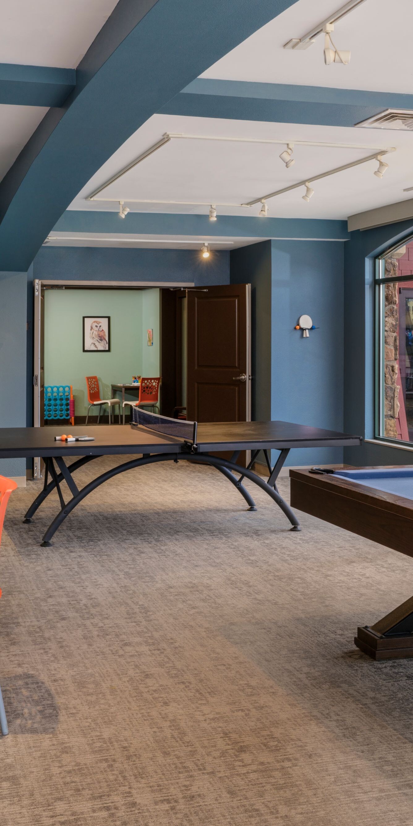 Room with billiards, table tennis, seating areas