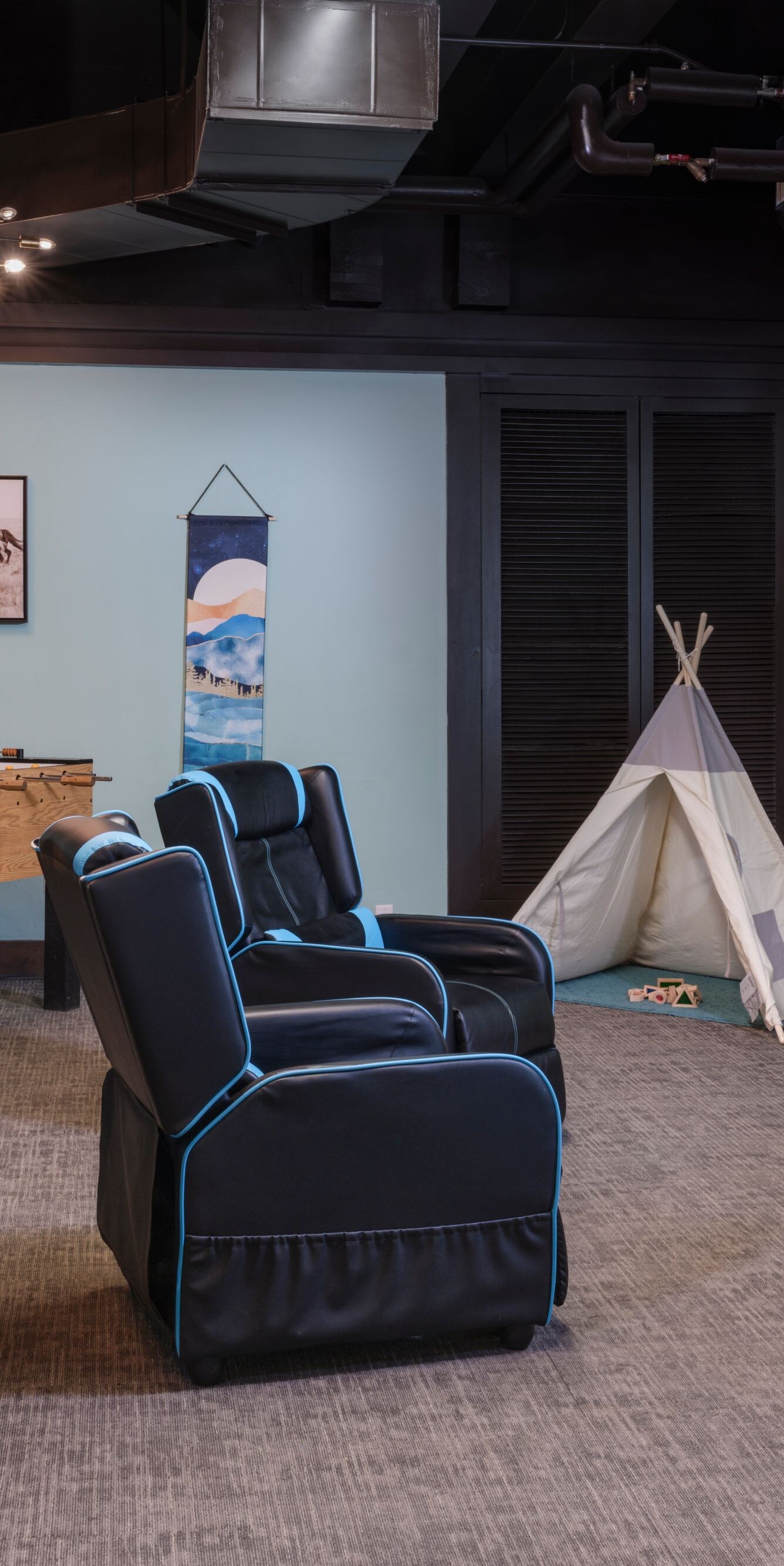 Room with foosball, TV on wall, teepee, seating