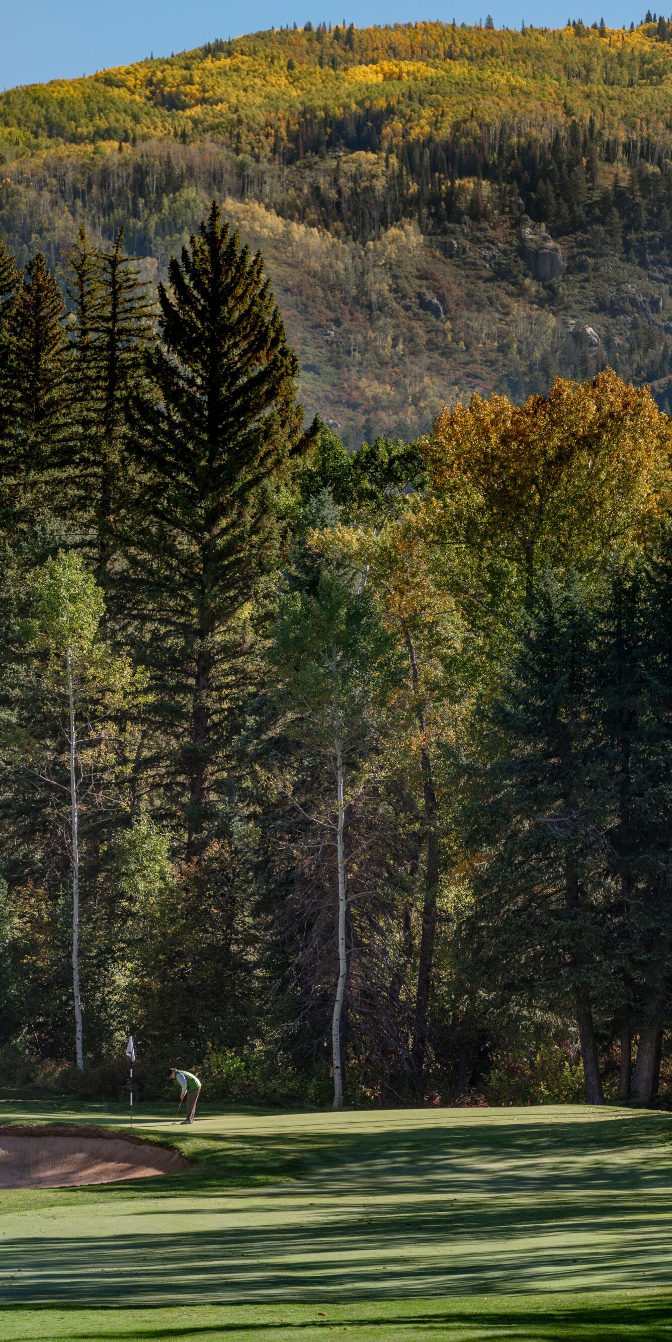 Player on golf course, view of mountains