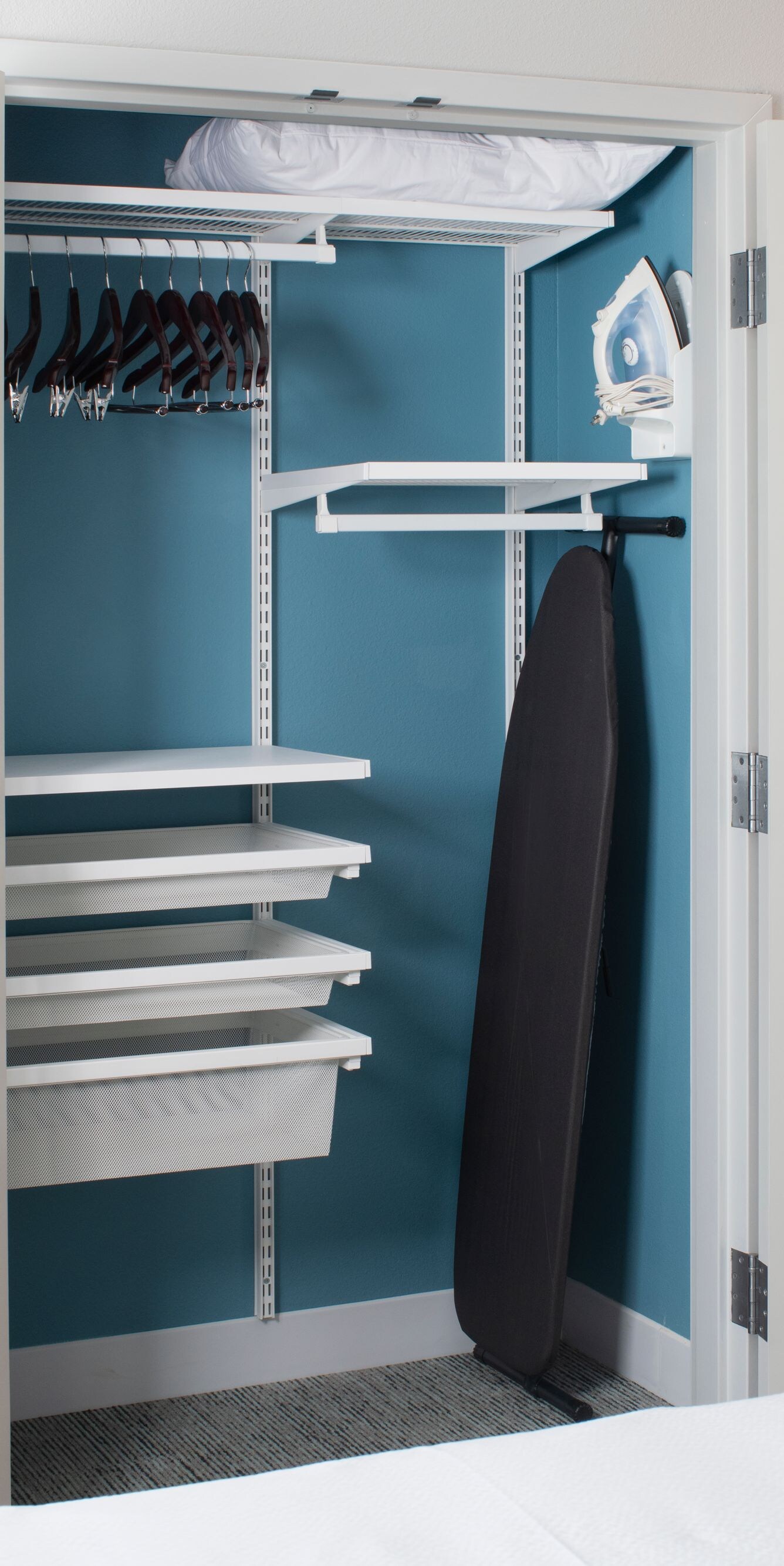 Open closet with shelving, hanging space, and iron