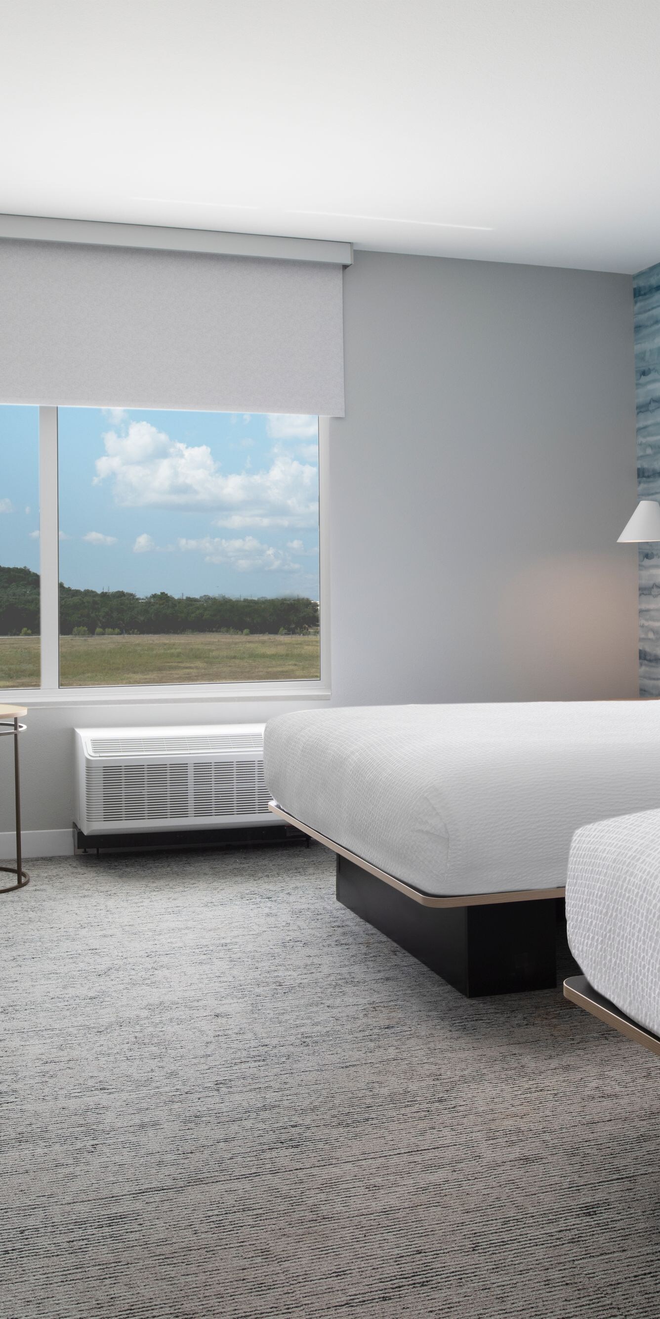 Guest room with two beds, workspace & window view