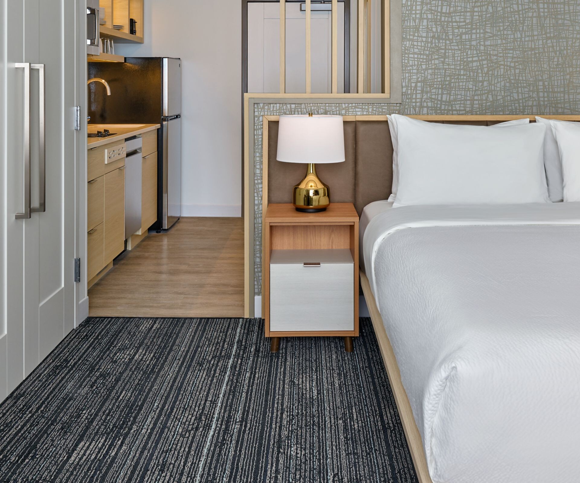 King bed in a guestroom showing kitchen.