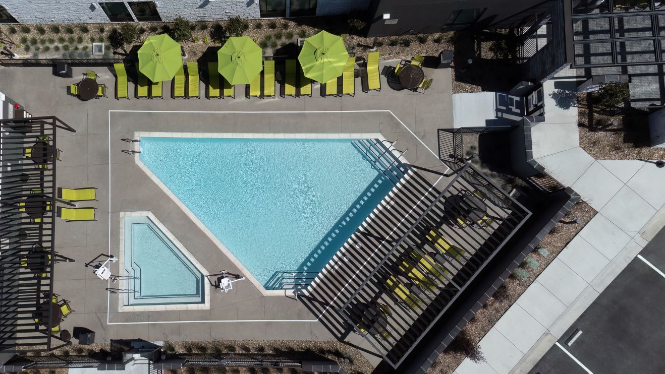 aerial view of outdoor pool and spa with seating