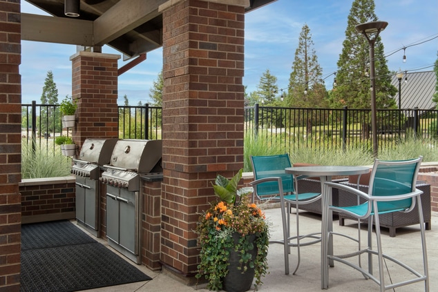 outdoor patio with two gas grills and seating