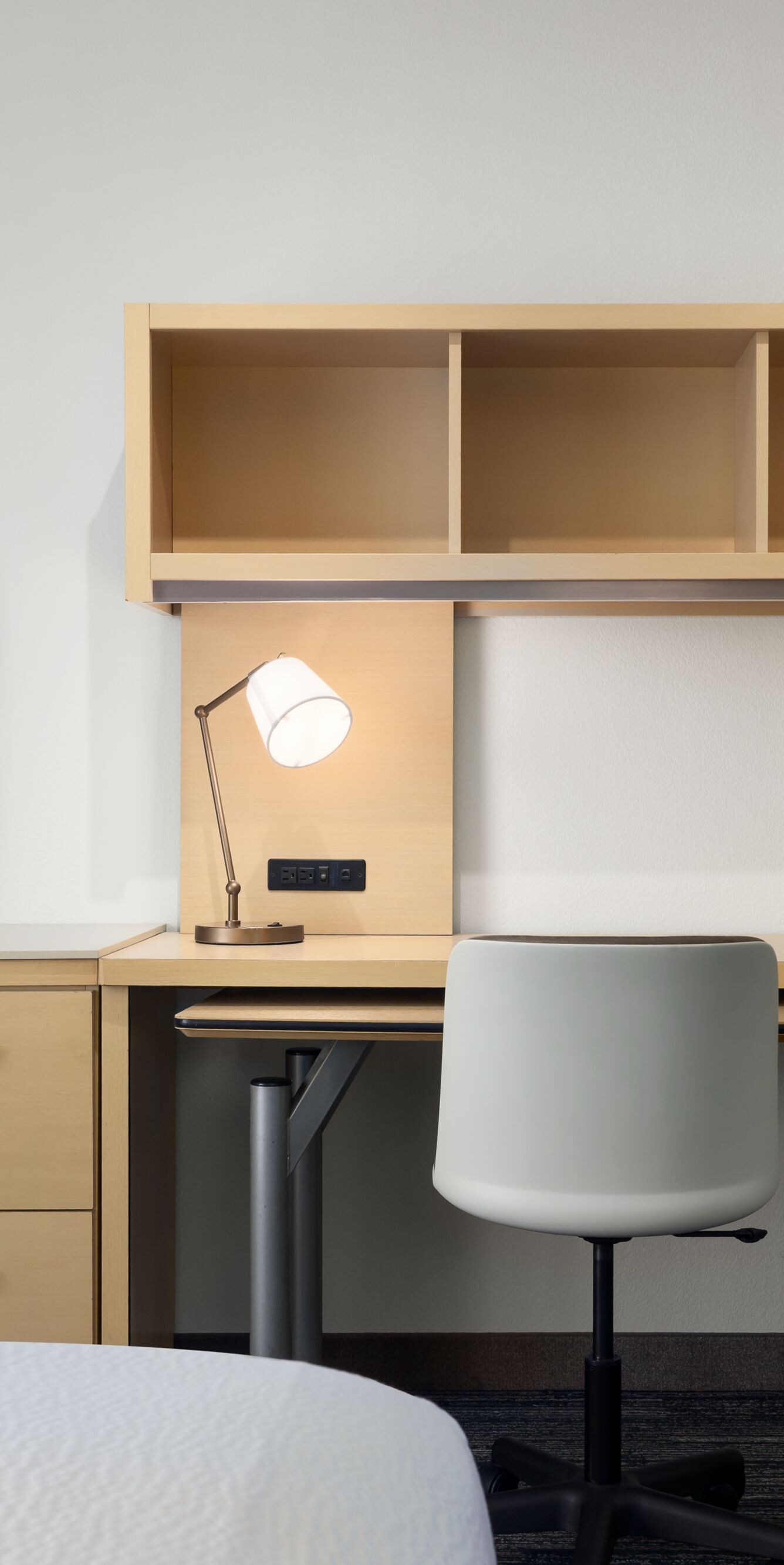 Hotel room desk with chair, TV and shelving