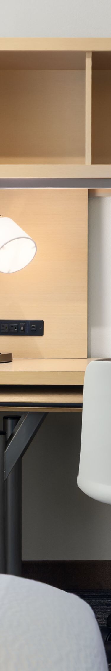 Hotel room desk with chair, TV and shelving
