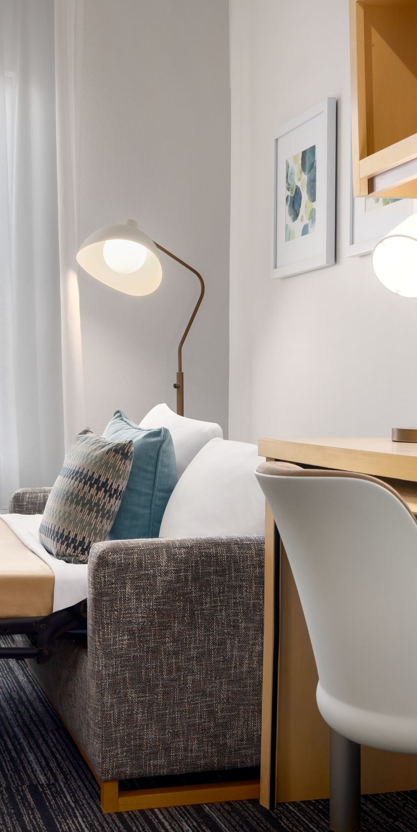 Hotel room desk with lamp and sofa sleeper