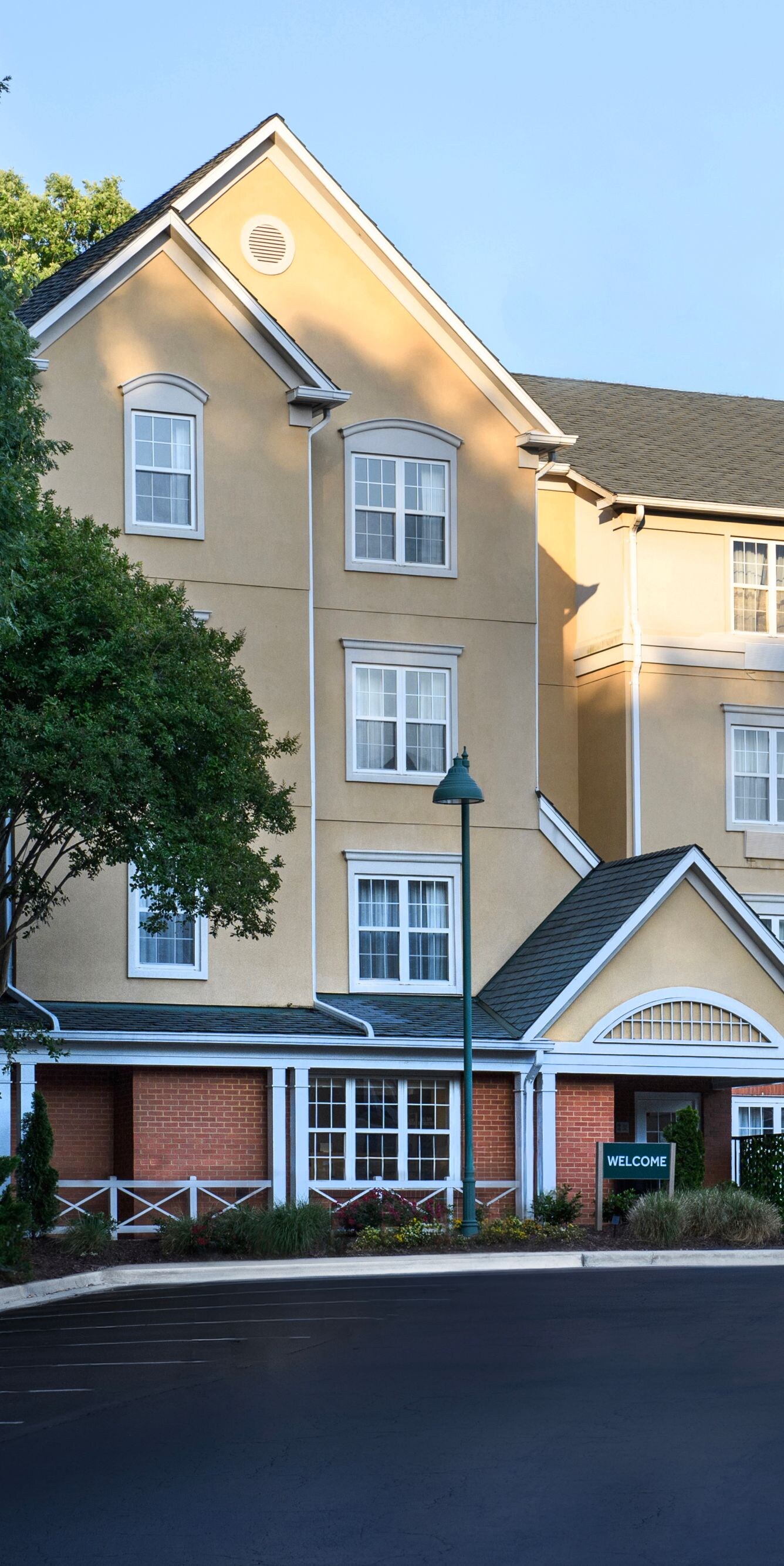 Hotel exterior with entrance, windows, and trees