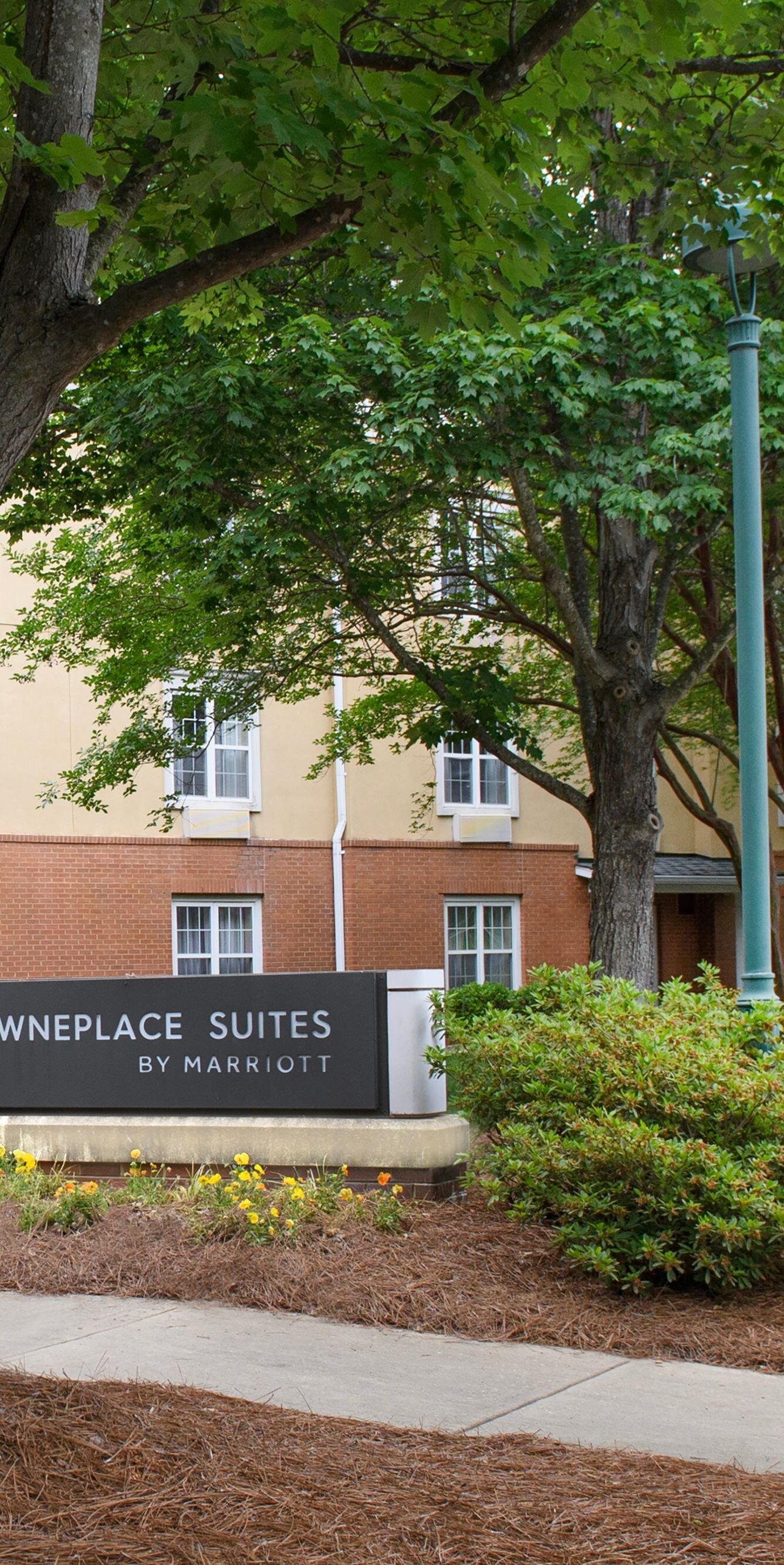 Hotel exterior sign with trees and walkway