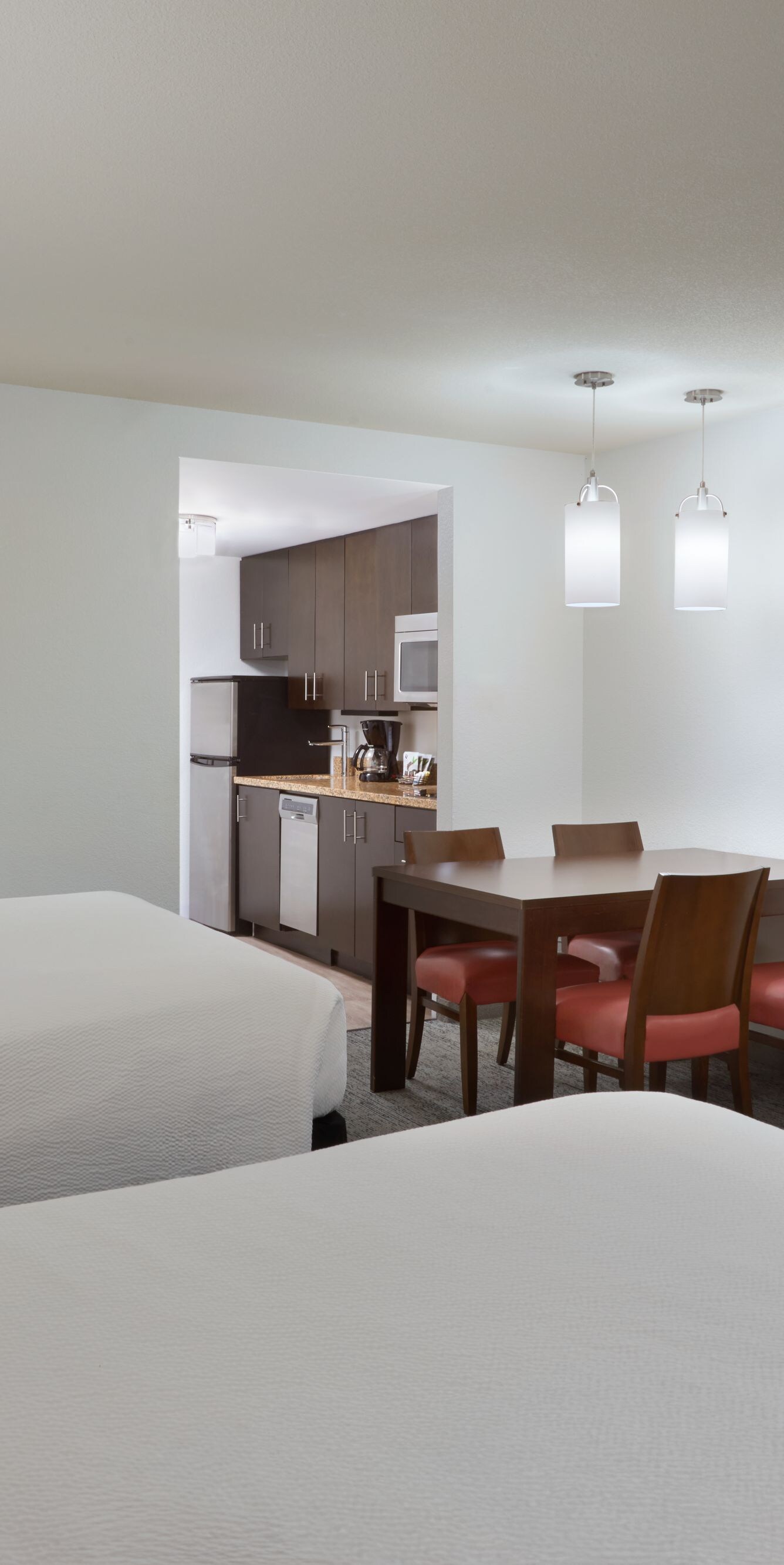 deux lits queen size, une table à manger, une télévision et une cuisine