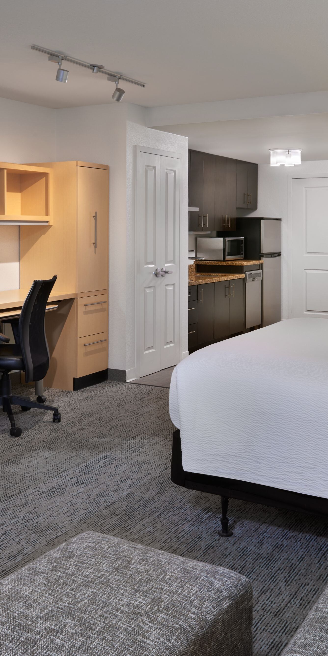 Lit king size, bureau de travail, cuisine et canapé-lit