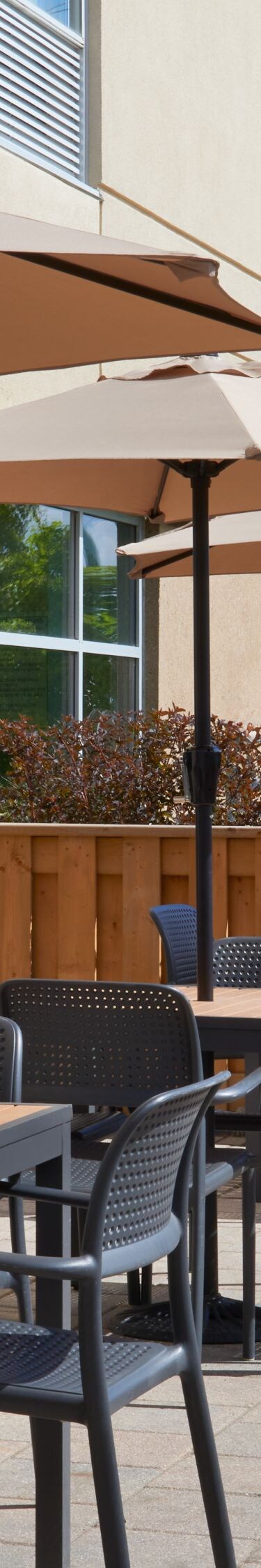 Terrasse extérieure avec tables, chaises et barbecue