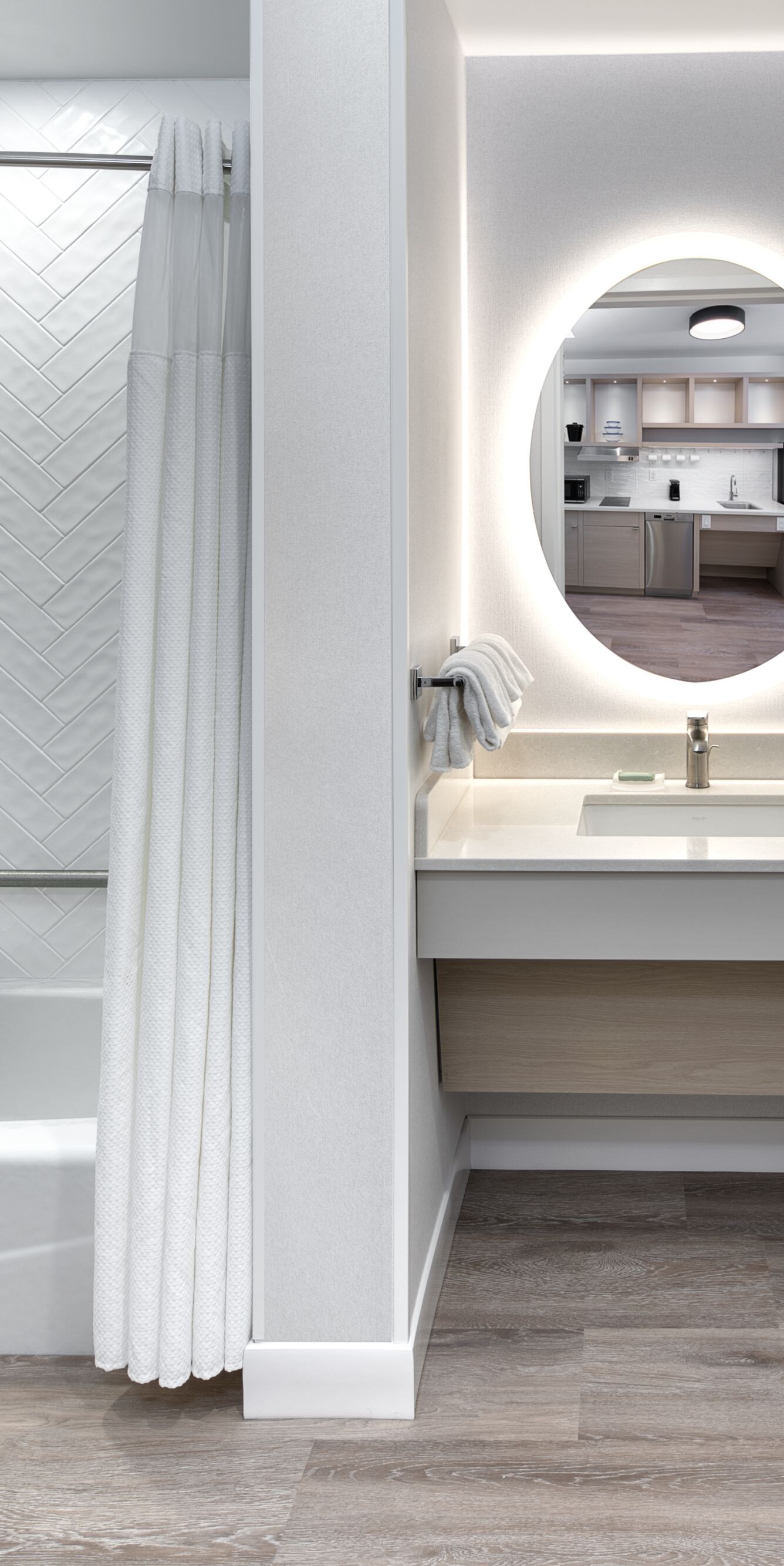 Salle de bain accessible aux personnes à mobilité réduite avec chaise pliante.
