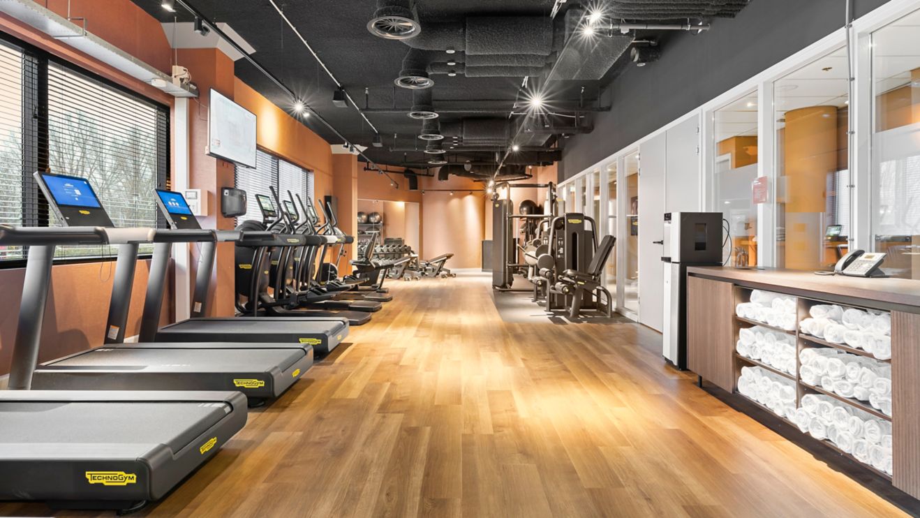 Modern gym with cardio machines and weights area