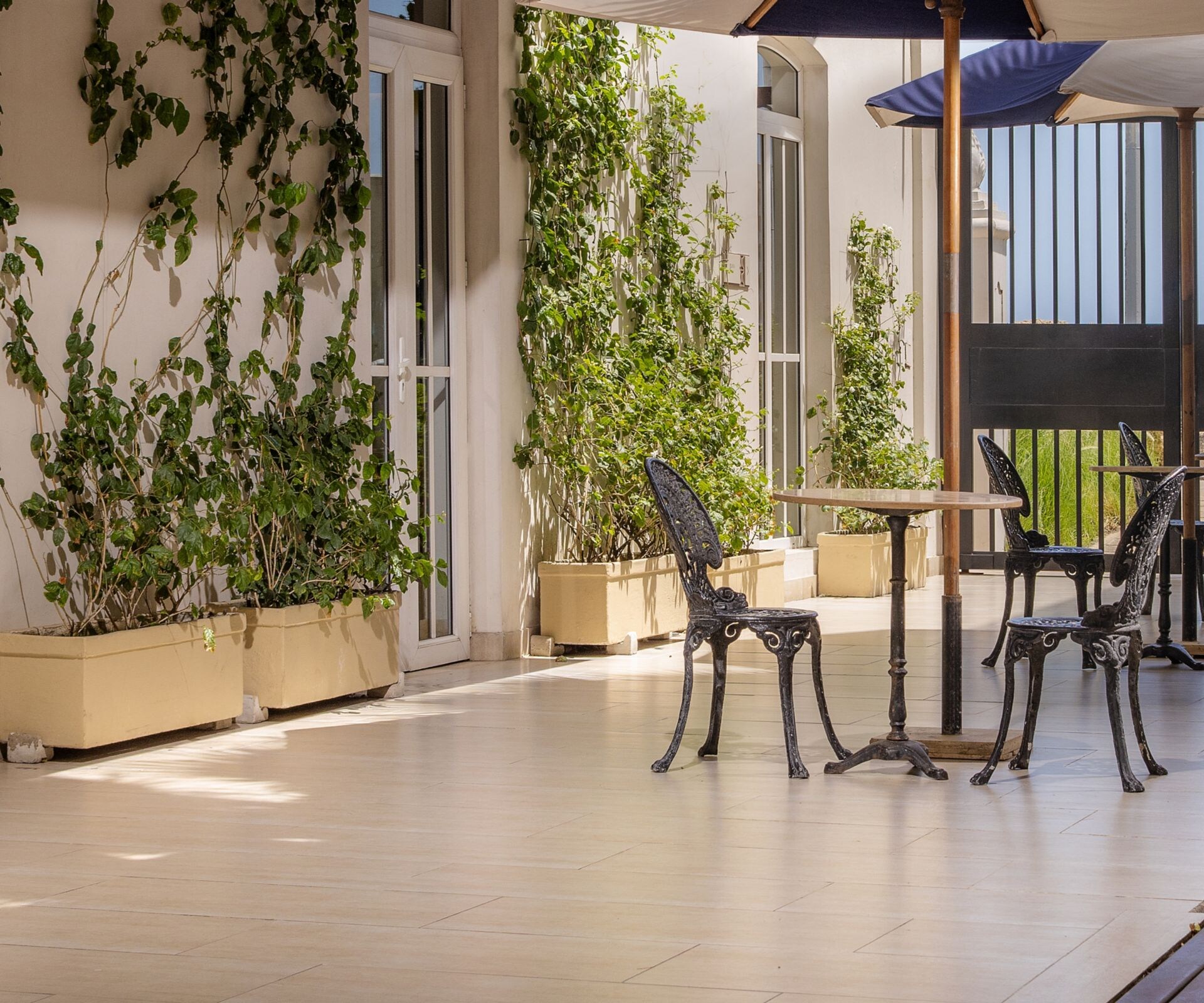 patio al aire libre con mesas, sillas y sombrillas