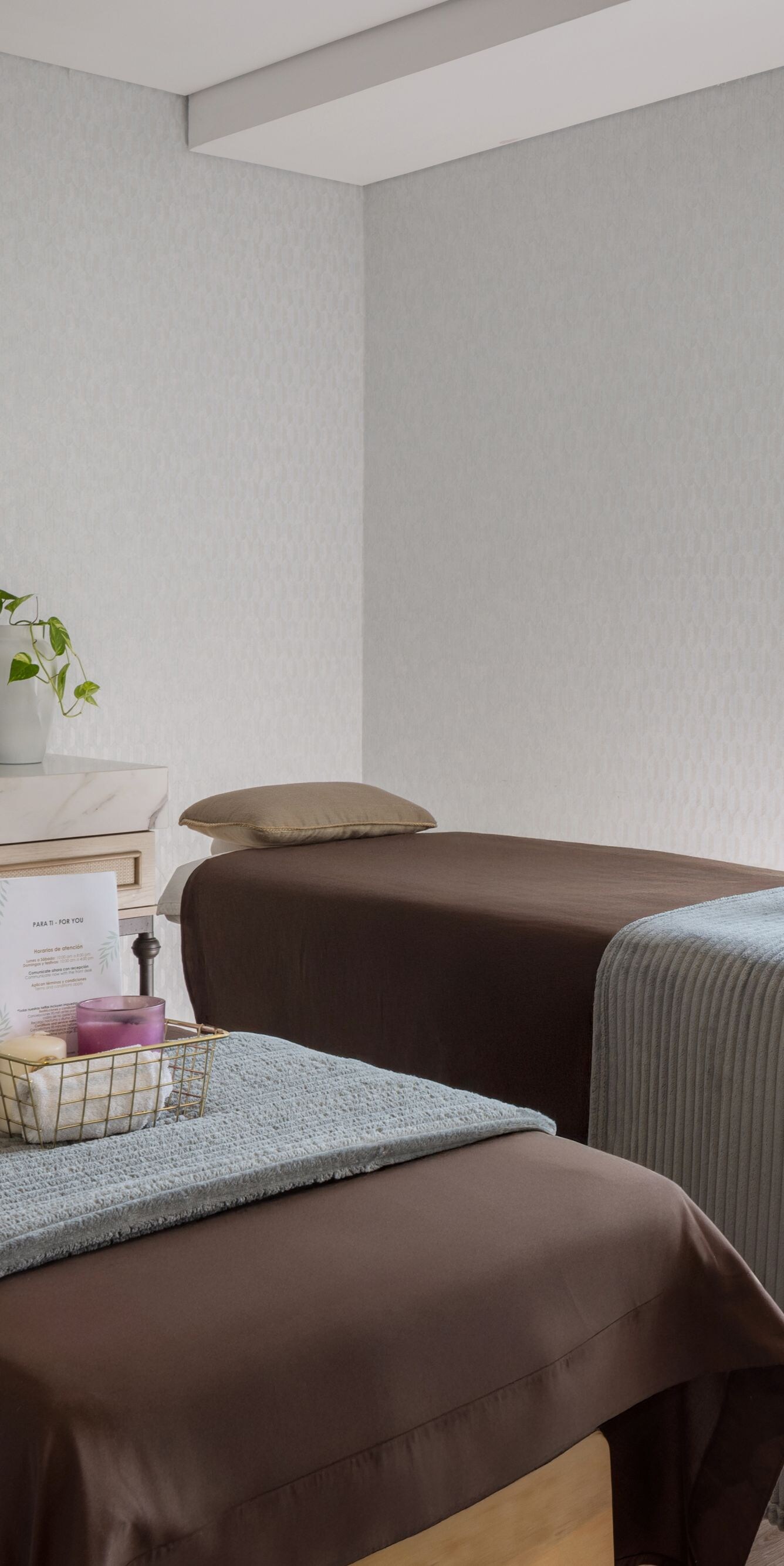 Dos camas de masaje de spa con ropa de cama marrón