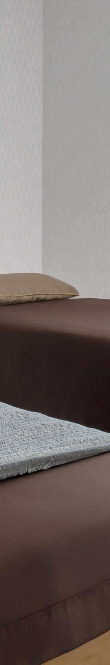 Dos camas de masaje de spa con ropa de cama marrón