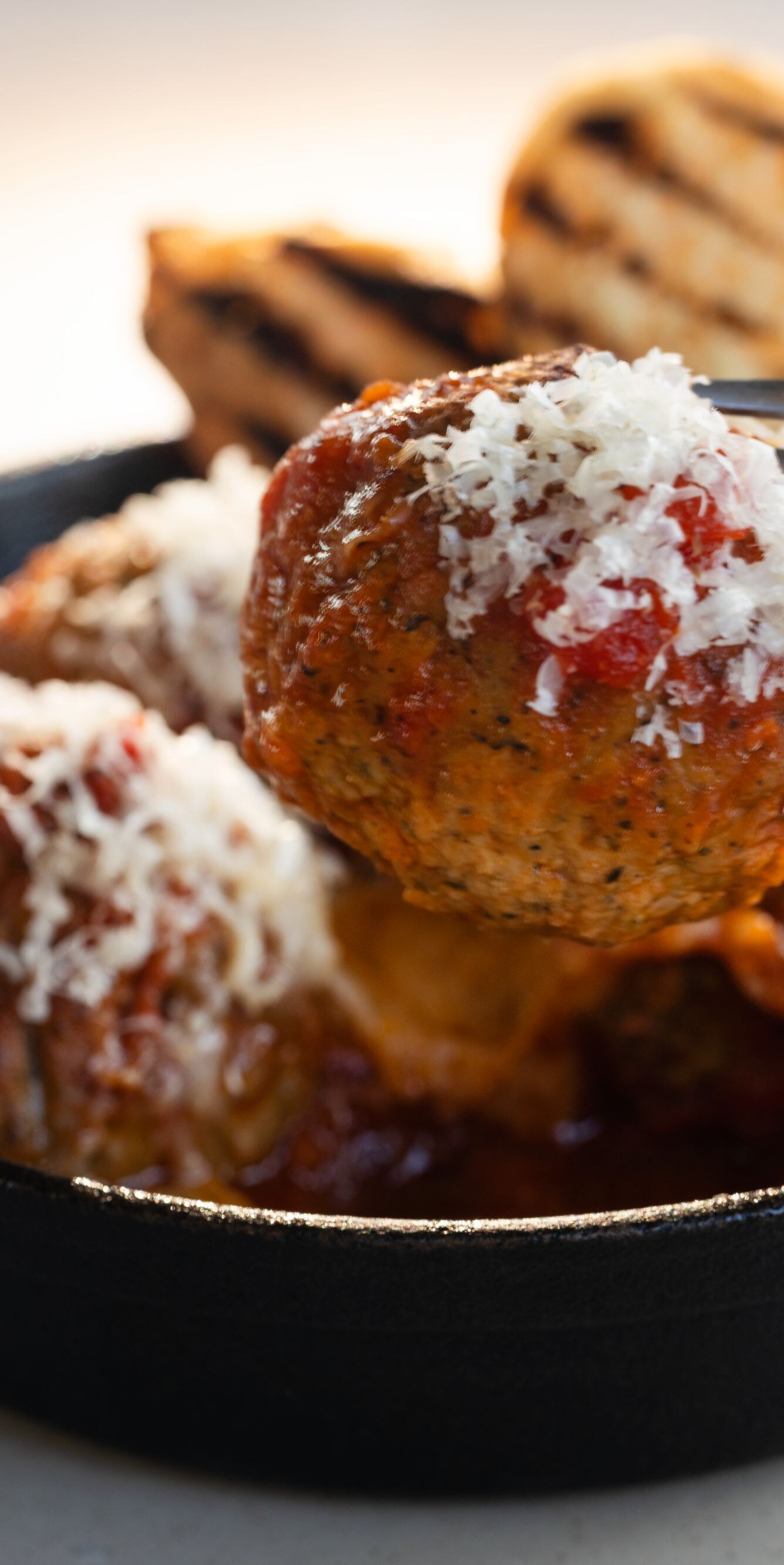 Meatball on fork with grated cheese
